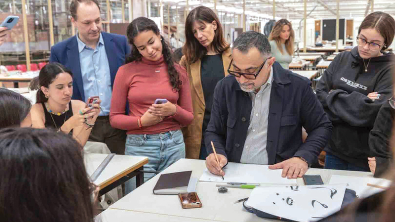 الفنان العراقي وسام شوكت خلال ورشة الخط في جامعة نافارا الإسبانية.  وام