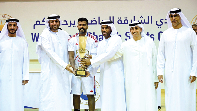 قائد فريق الشارقة أحمد هلال يتسلم الكأس من رئيس «اتحاد اليد» نبيل عاشور ورئيس مجلس الشارقة الرياضي عيسى هلال.	  تصوير: باتريك كاستيلو