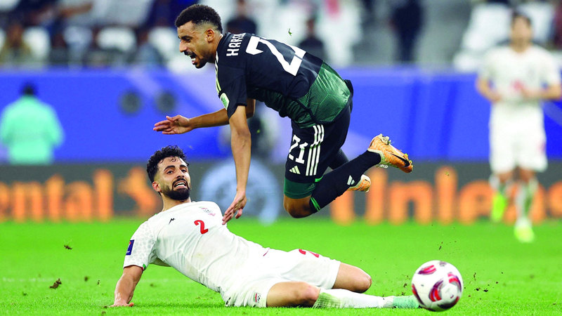 لاعب المنتخب حارب عبدالله يتفادى تدخلاً قوياً من اللاعب الإيراني صادق محرمي. رويترز