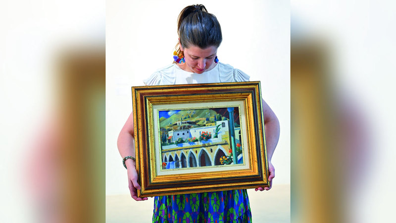 ألكسندرا روي تحمل لوحة سعيد «بيوت في عيتنيت». من المصدر