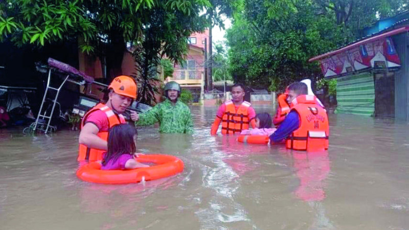 عمال الإنقاذ الفلبينيون ينقذون طفلين علقا بمياه الفيضانات. إي.بي.إيه