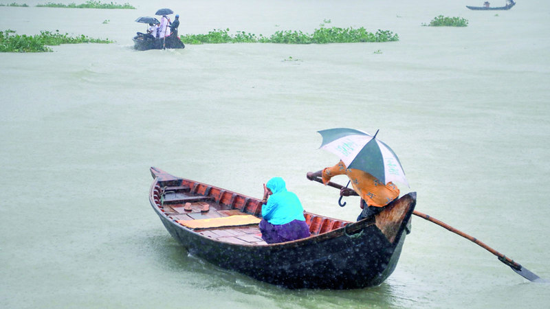 امرأة تعبر نهر بوريجانجا بالقارب في دكا.  إي.بي.إيه