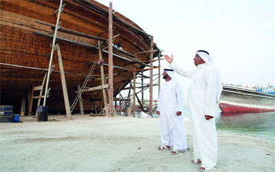 الأخوان حريز وصلاح بن طوق المـــــــــــــــــــــــــــــــــــري يشرفان على بناء السفينة «فزاع».	 تصوير: أحمد عراديتي