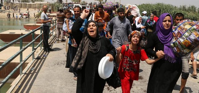 عراقيون فرّوا من العنف في الرمادي يعبرون جسر بزيبز للوصول إلى بغداد. أ.ب